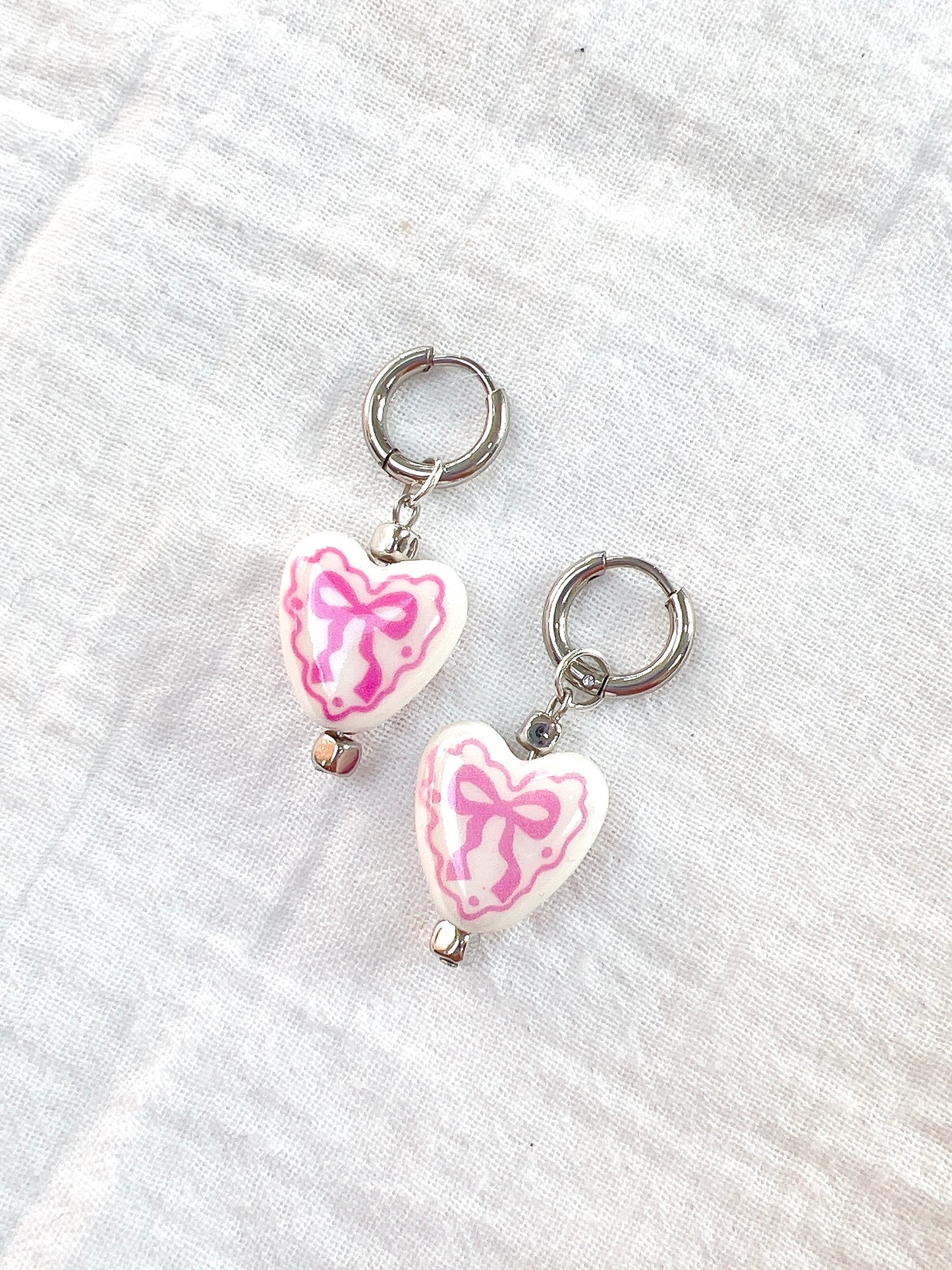 “Chloë” - Porcelain Bow Hearts on Silver Huggie Hoops